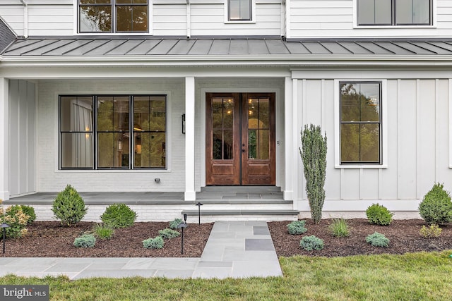 property entrance with french doors, board and batten siding, and a standing seam roof