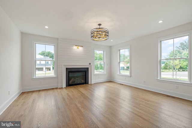 unfurnished living room featuring light wood finished floors, visible vents, and baseboards