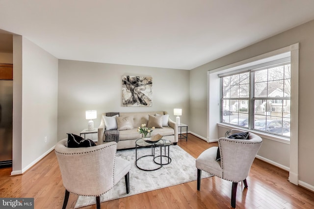 living area featuring light wood-style floors and baseboards