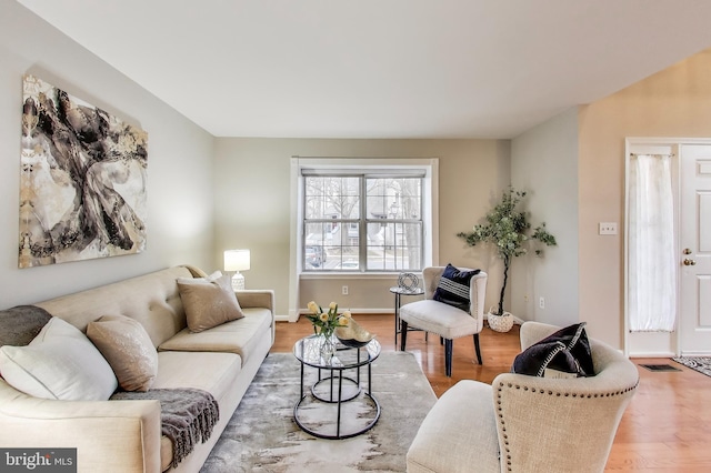 living area featuring baseboards and wood finished floors