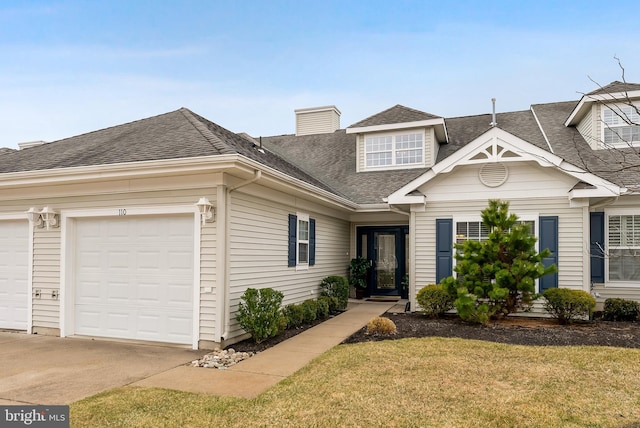 view of front of house with an attached garage, a shingled roof, concrete driveway, a front lawn, and a chimney