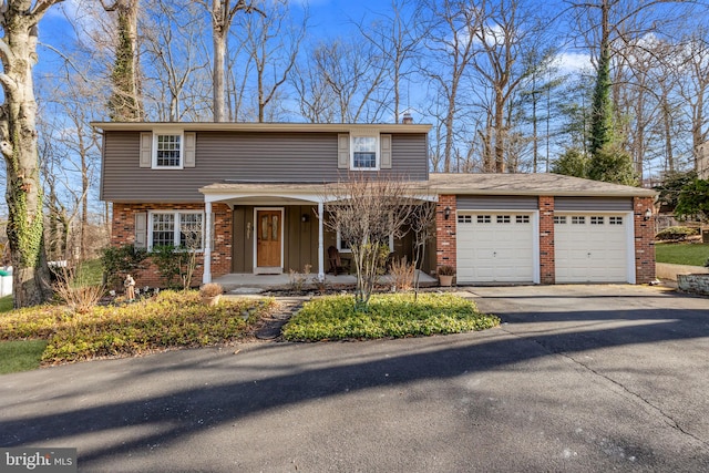 view of front of property featuring brick siding, driveway, and an attached garage