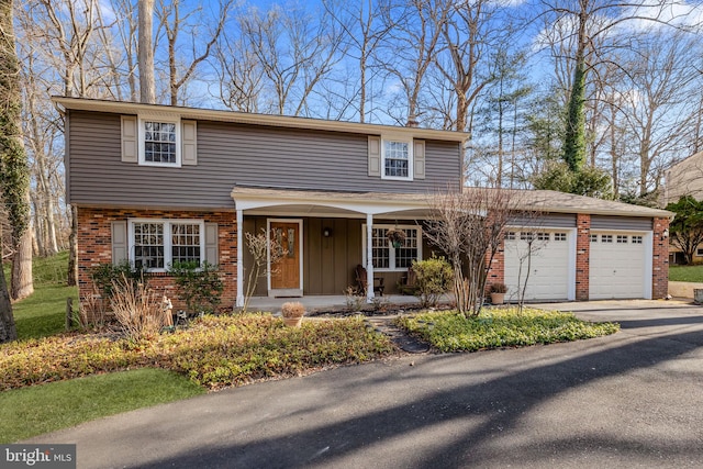 traditional-style house featuring concrete driveway, brick siding, an attached garage, and covered porch