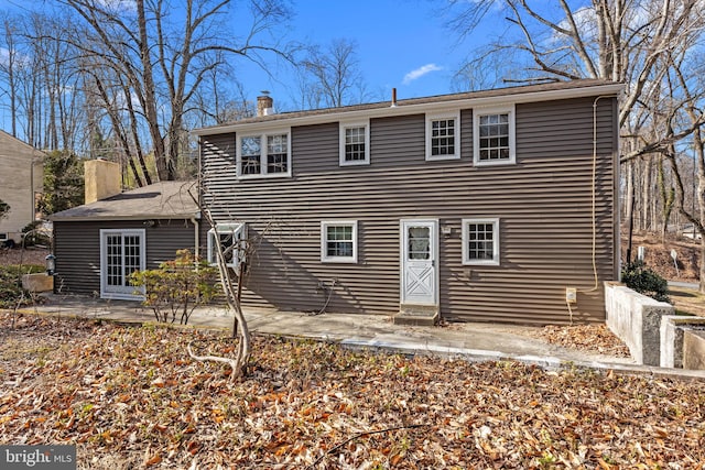 back of property featuring a chimney and a patio