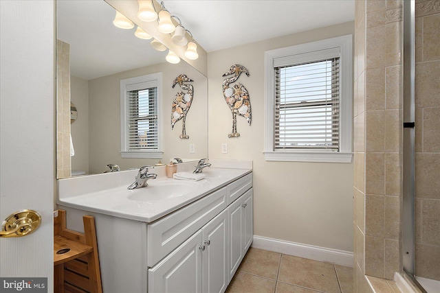 bathroom with baseboards, double vanity, a sink, and tile patterned floors