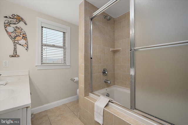 bathroom with baseboards, toilet, tiled shower / bath combo, tile patterned flooring, and vanity