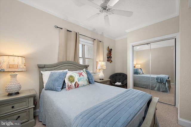 carpeted bedroom with ceiling fan, a textured ceiling, ornamental molding, and a closet