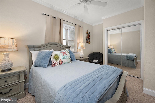 bedroom with a ceiling fan, a closet, ornamental molding, and carpet flooring