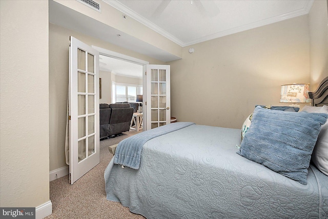 bedroom with carpet floors, visible vents, baseboards, french doors, and crown molding