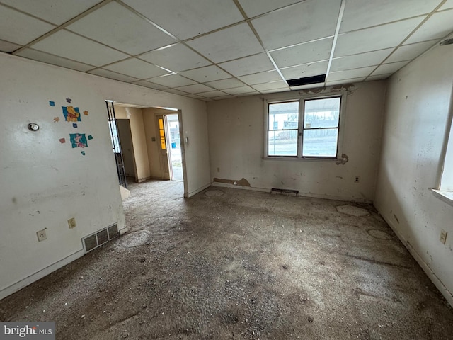 empty room featuring visible vents and a drop ceiling