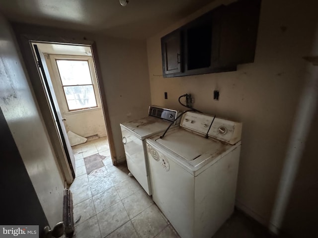 washroom with light tile patterned floors, cabinet space, and washer and dryer