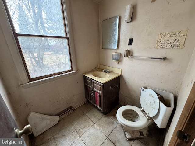 bathroom with toilet, tile patterned flooring, and vanity