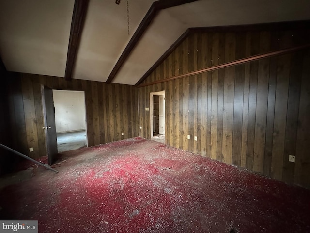 additional living space featuring vaulted ceiling with beams, carpet flooring, and wooden walls