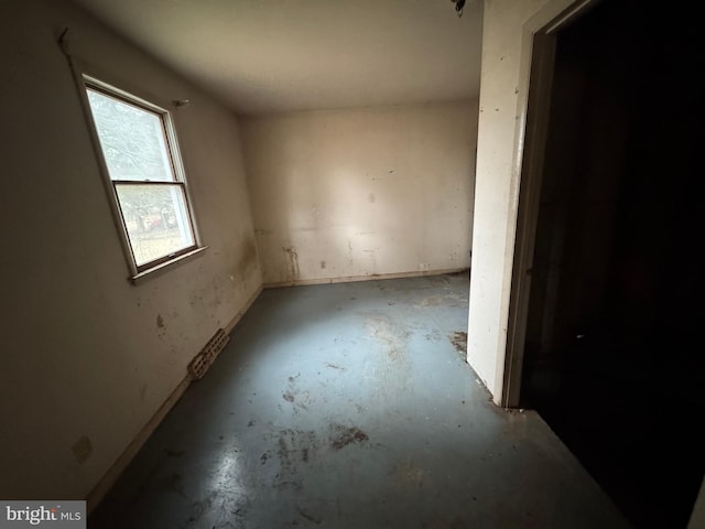 unfurnished room with concrete flooring