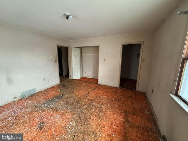 unfurnished bedroom featuring a closet and visible vents