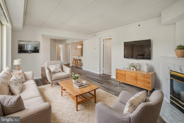 living area with a fireplace, wood finished floors, and baseboards