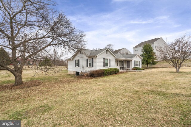 view of front of property with a front yard, central AC unit, and a shingled roof