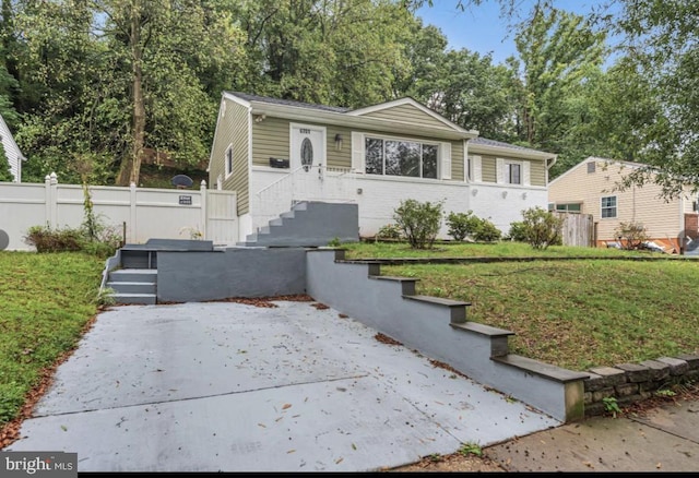 view of front of house featuring brick siding, fence, and a front yard