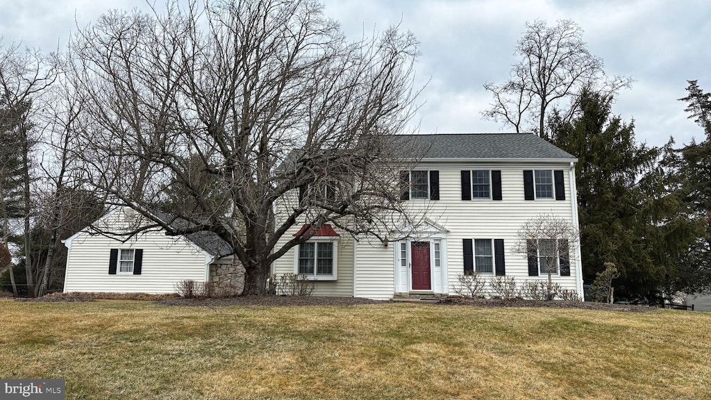 colonial home featuring entry steps and a front lawn