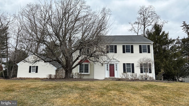 colonial home featuring entry steps and a front lawn