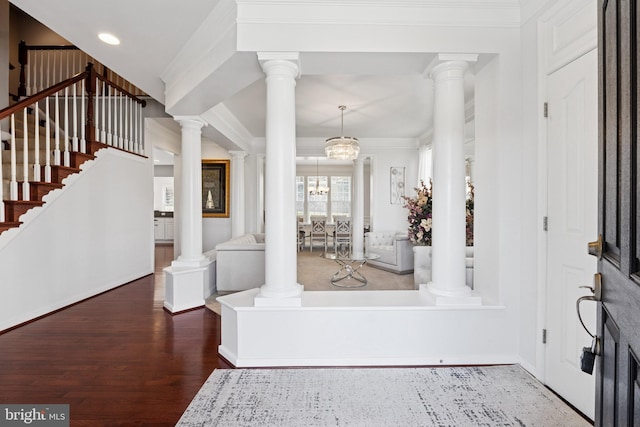 entryway featuring decorative columns, wood finished floors, and ornamental molding