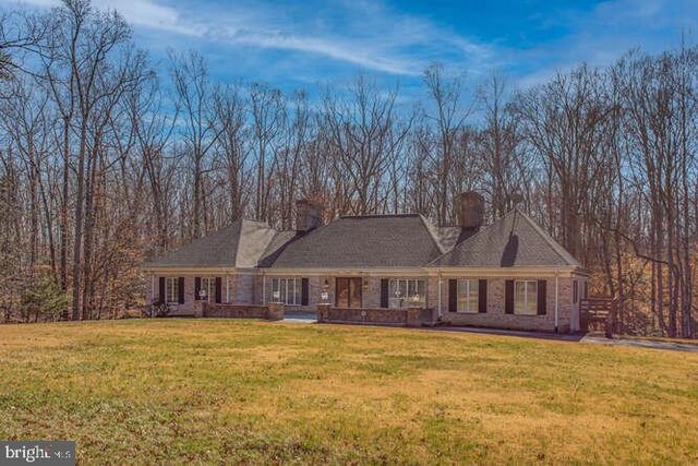 view of front of property with a chimney and a front lawn