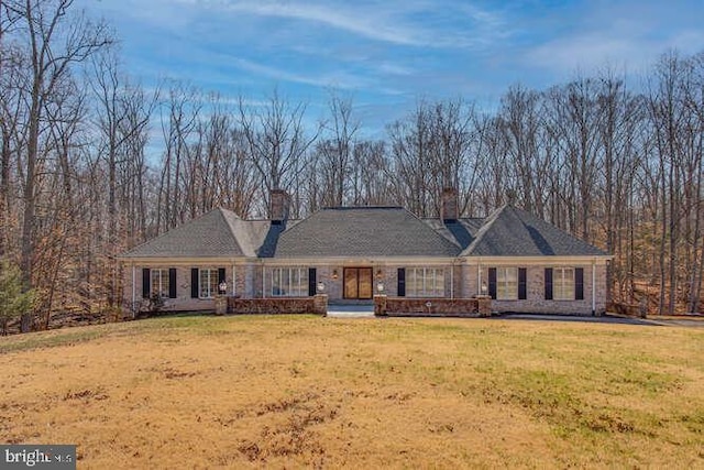 view of front of house featuring a chimney and a front yard