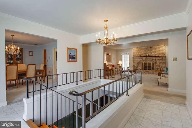 corridor featuring marble finish floor, a chandelier, ornamental molding, and an upstairs landing