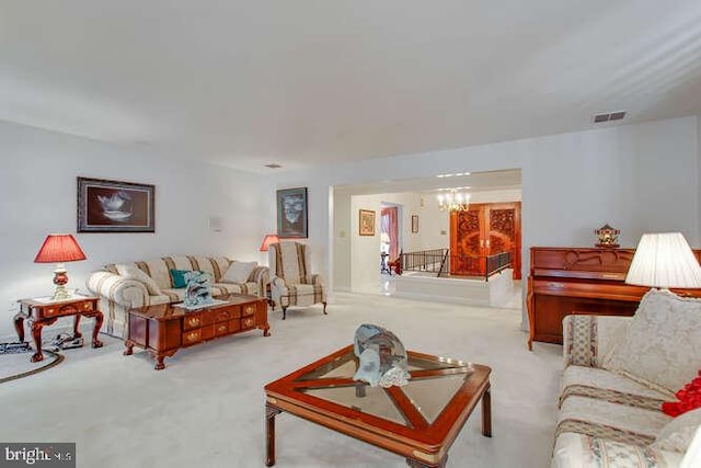 living room featuring carpet flooring, visible vents, and a notable chandelier