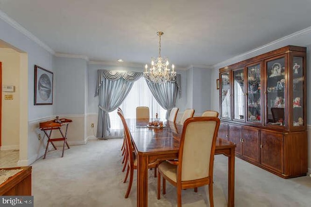 dining room with light carpet, ornamental molding, baseboards, and a notable chandelier