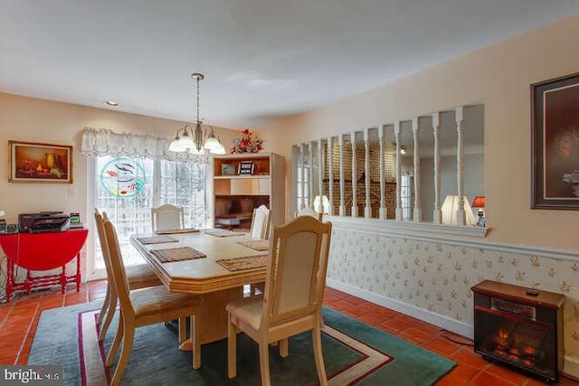 tiled dining area with wallpapered walls, baseboards, and an inviting chandelier