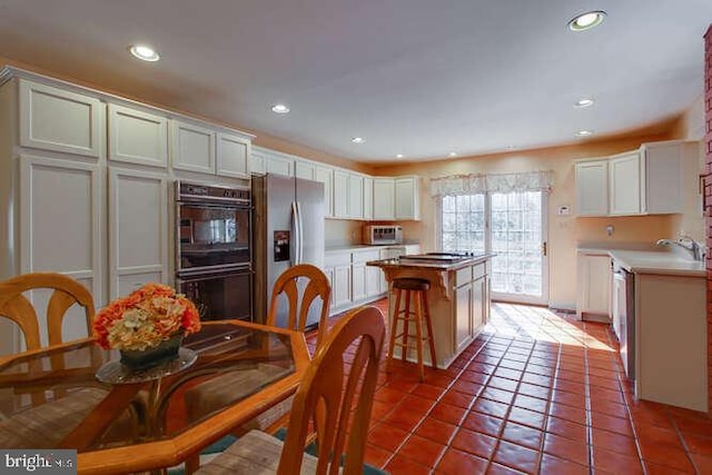 kitchen featuring appliances with stainless steel finishes, tile patterned flooring, a kitchen island, and recessed lighting