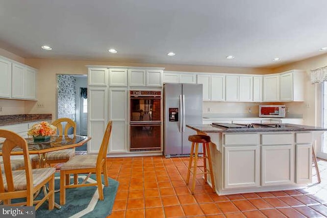 kitchen with stainless steel refrigerator with ice dispenser, light tile patterned floors, recessed lighting, dobule oven black, and white cabinetry