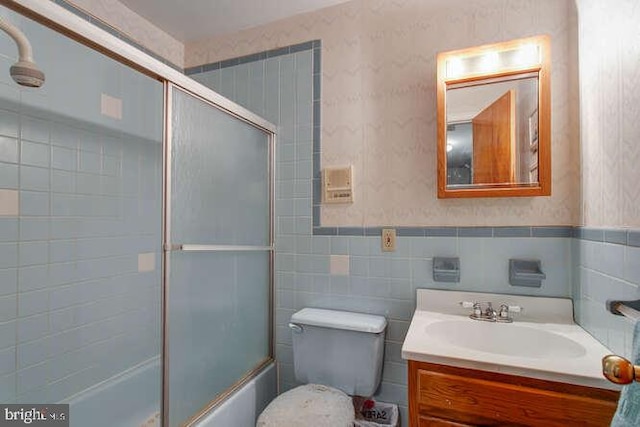 bathroom featuring a wainscoted wall, vanity, and wallpapered walls