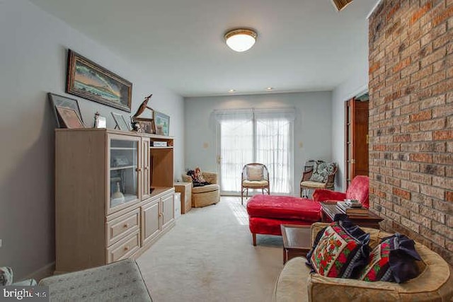 sitting room with brick wall and carpet flooring