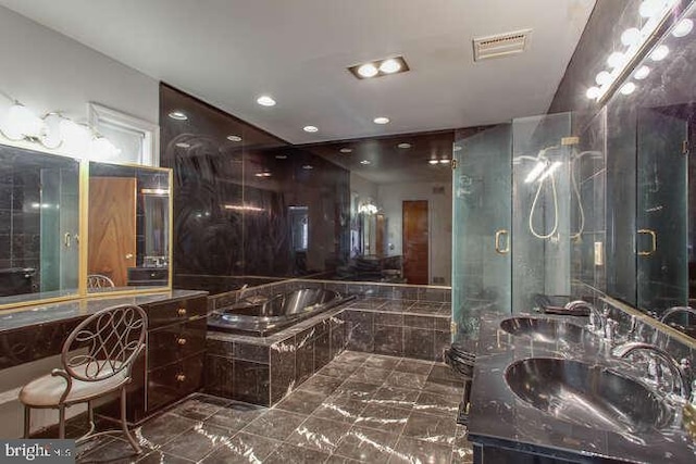 bathroom featuring visible vents, a garden tub, and vanity