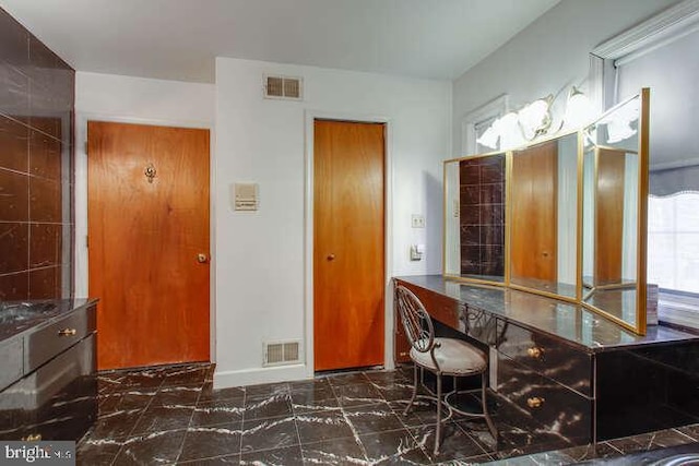 interior space with marble finish floor, visible vents, and baseboards