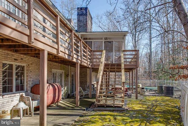 rear view of property with a patio, fence, stairway, a wooden deck, and a chimney