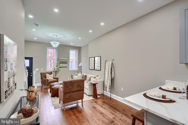 living area featuring baseboards, wood finished floors, and recessed lighting