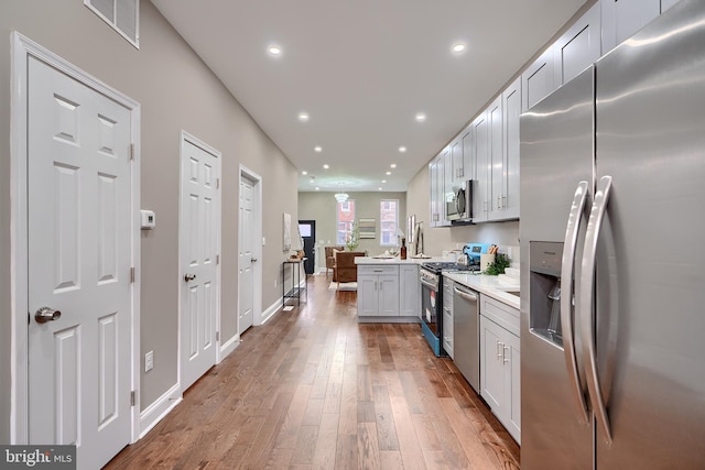 kitchen with visible vents, hardwood / wood-style floors, stainless steel appliances, light countertops, and recessed lighting