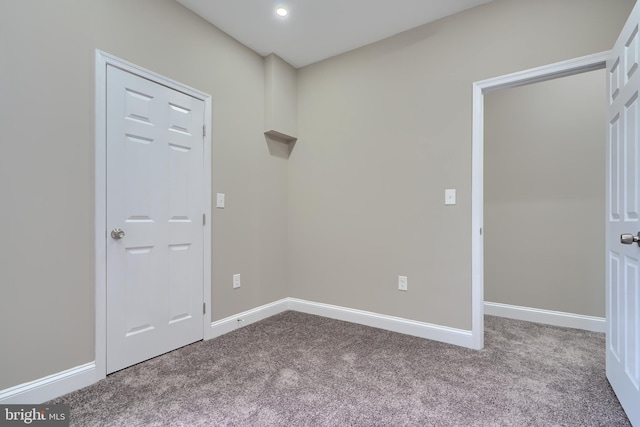 carpeted empty room featuring baseboards