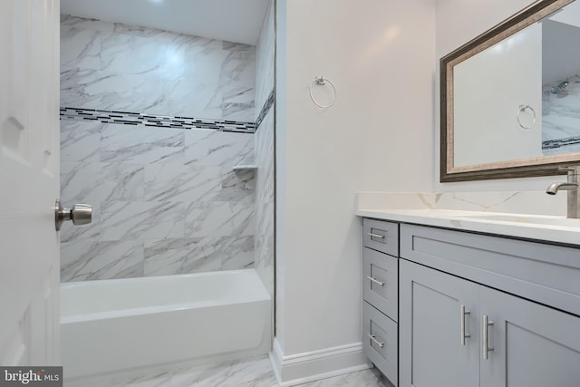 bathroom featuring marble finish floor, tub / shower combination, vanity, and baseboards