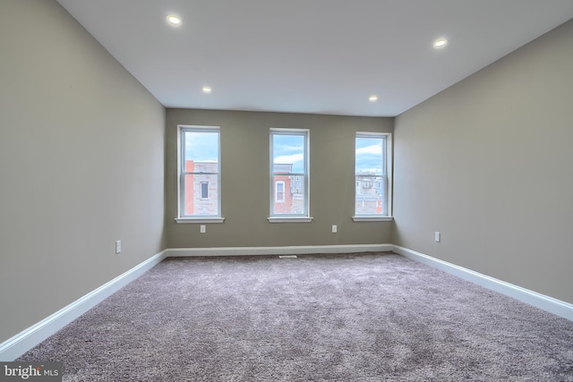 carpeted spare room featuring baseboards and recessed lighting