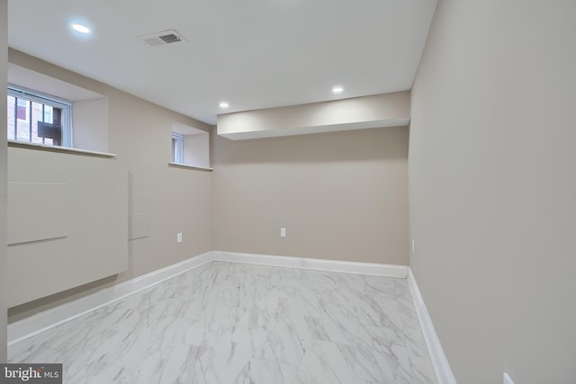 below grade area featuring recessed lighting, marble finish floor, visible vents, and baseboards