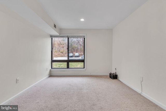 spare room featuring carpet floors, visible vents, baseboards, and recessed lighting