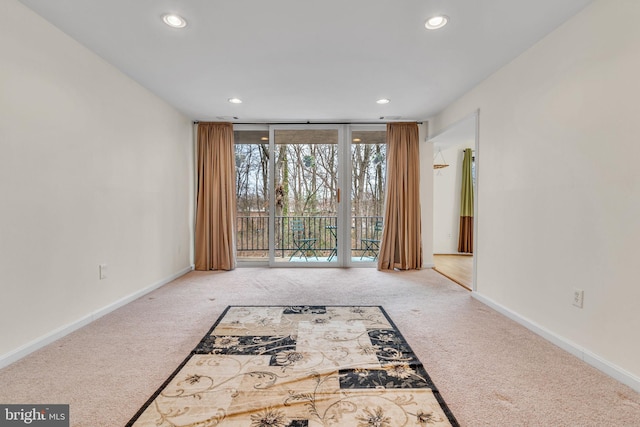 unfurnished living room featuring baseboards, carpet floors, recessed lighting, and floor to ceiling windows