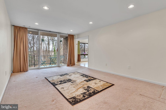 unfurnished living room featuring floor to ceiling windows, carpet, recessed lighting, and baseboards