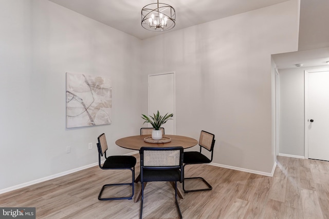 dining area with a notable chandelier, light wood-type flooring, and baseboards