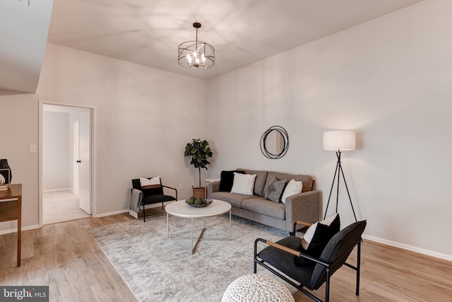 living room featuring baseboards, an inviting chandelier, and wood finished floors