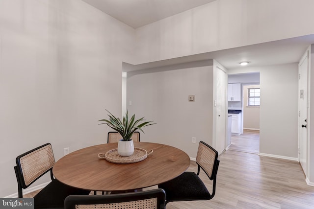 dining room with light wood-type flooring and baseboards